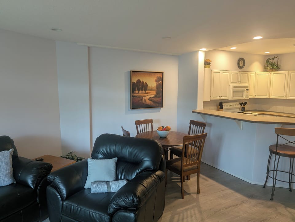 The dining area has wooden table that seats four people.