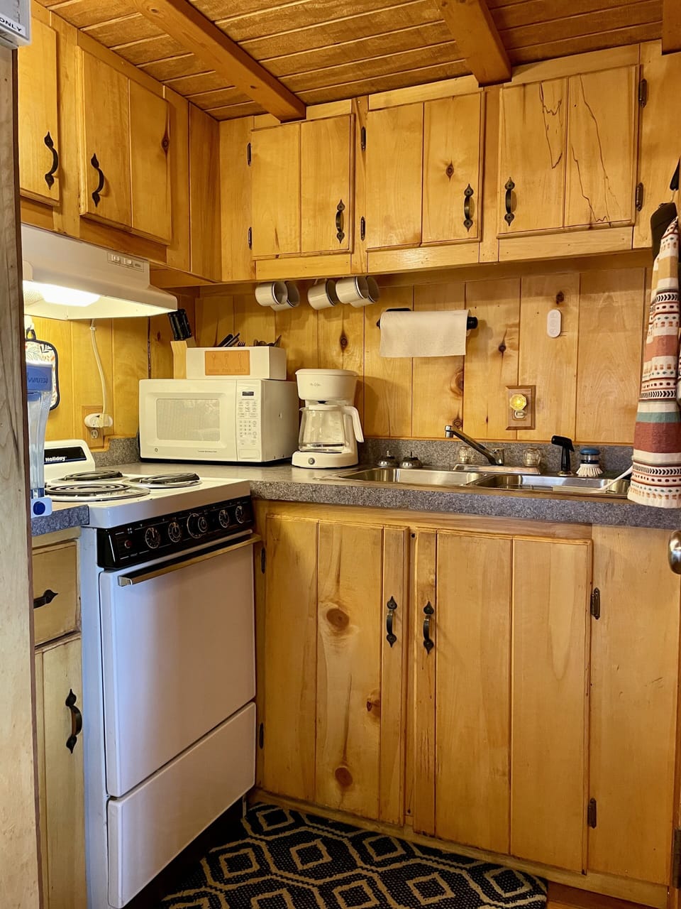 Fully equipped kitchen with stove/oven, microwave, dishes and sink. 