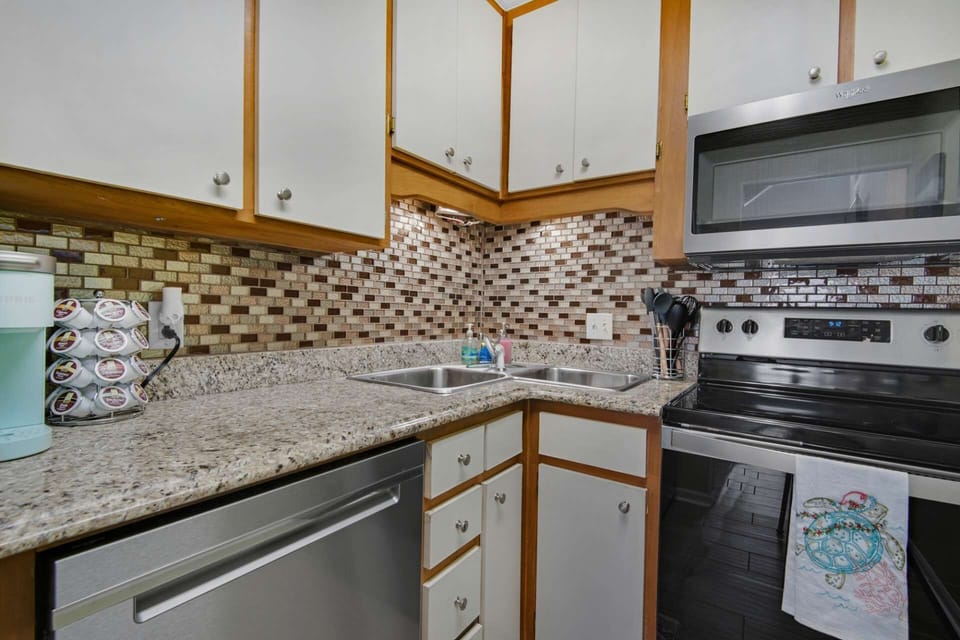 The quaint yet functional kitchen area includes stainless steel appliances, offering a well-equipped cooking space.