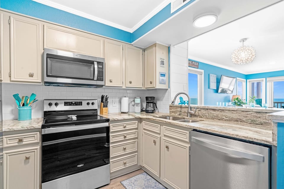 Full kitchen with microwave, stove, oven, and cooking utensils
