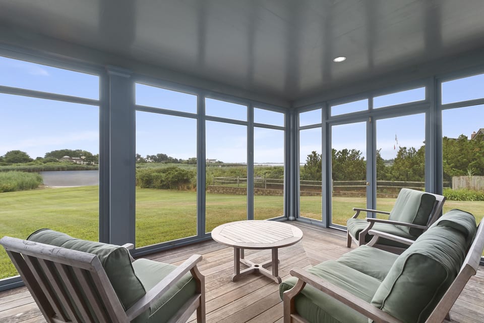 A restful shaded porch, providing screened comfort & expansive water views.