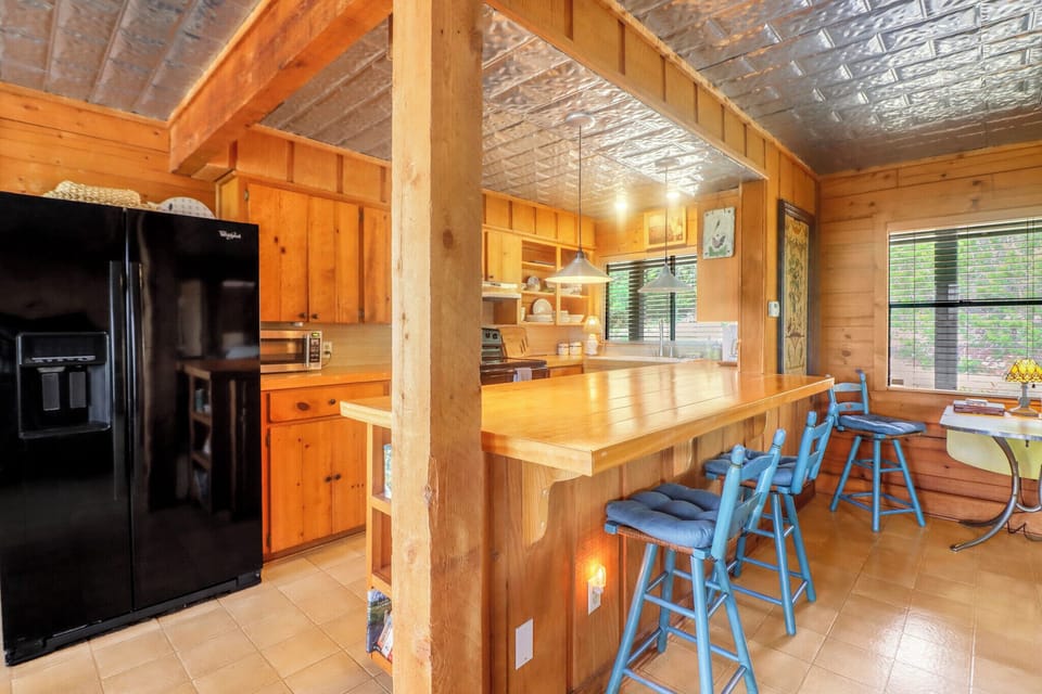 Your cabin getaway features a spacious kitchen with a breakfast bar, natural wood details, and modern appliances