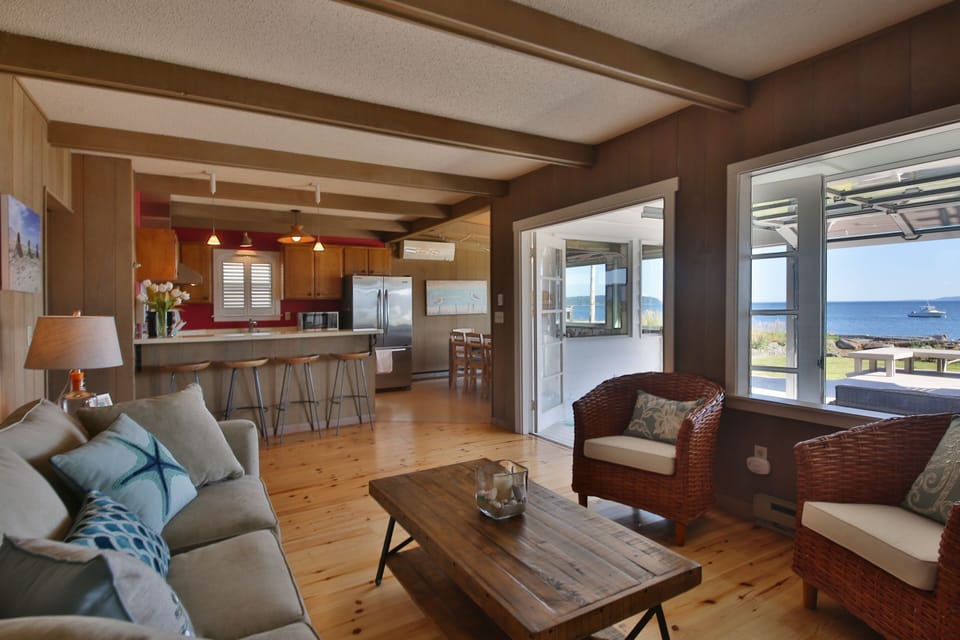 Open kitchen with gas stove and lots of small appliances, pots, pans and dishes