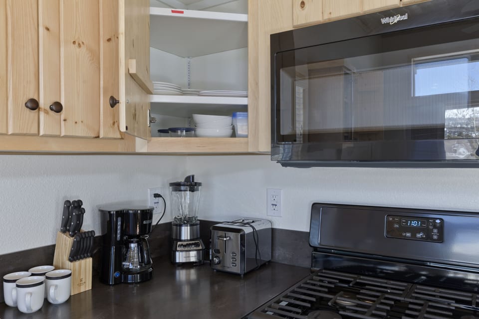 Full kitchen with appliances, cutlery, and dishes