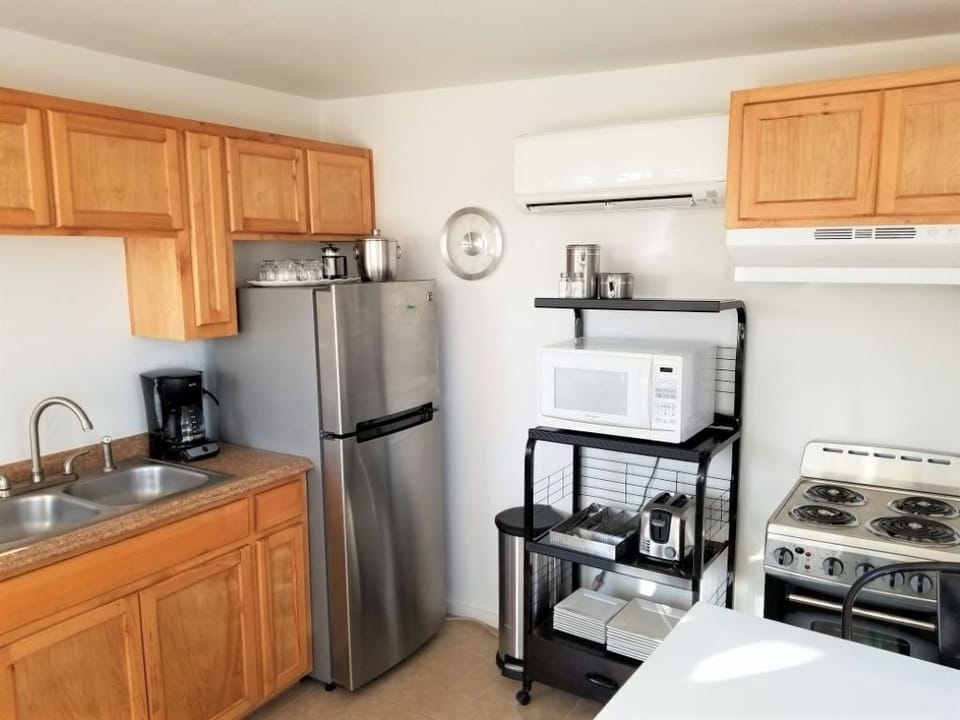 kitchen has apartment size frig, stove, microwave, coffee, blender, toaster