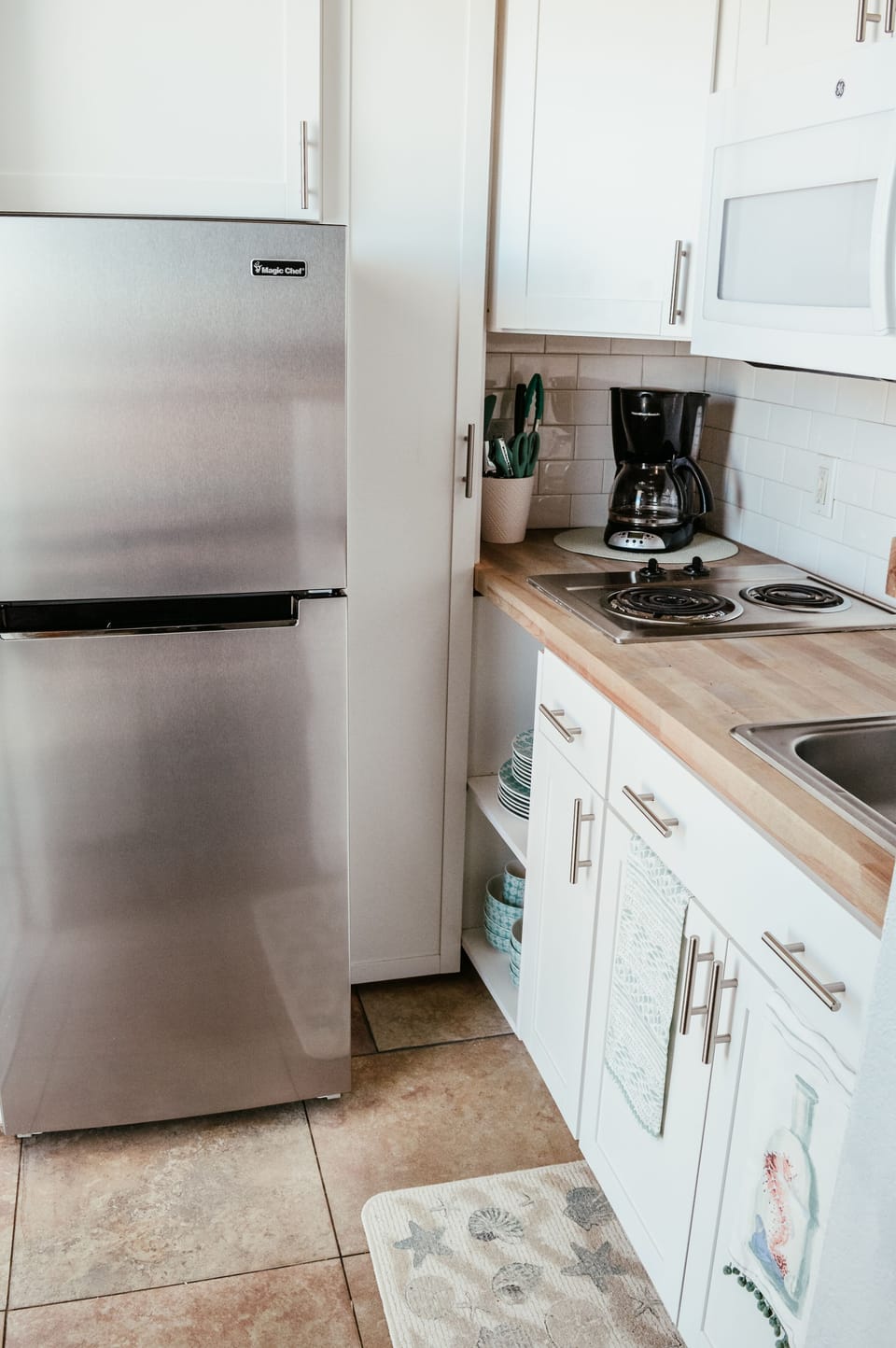 Stainless refrigerator, stove-top, microwave and coffee pot .