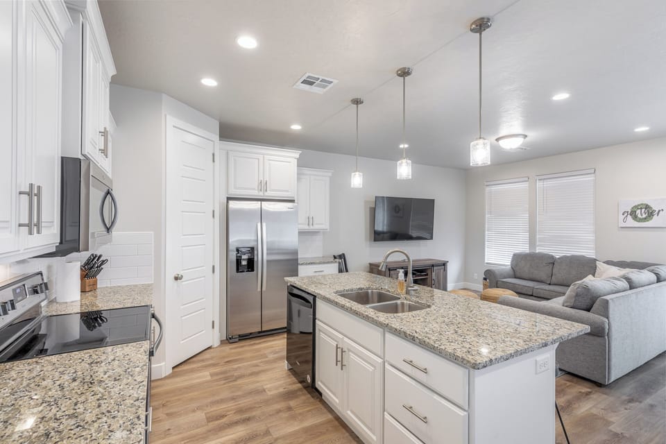 Kitchen Side View - The kitchen is fully stocked with all the dishes, cookware, baking pans, and cutlery you will need for meal preparations and includes stainless steel appliances and granite counter tops.