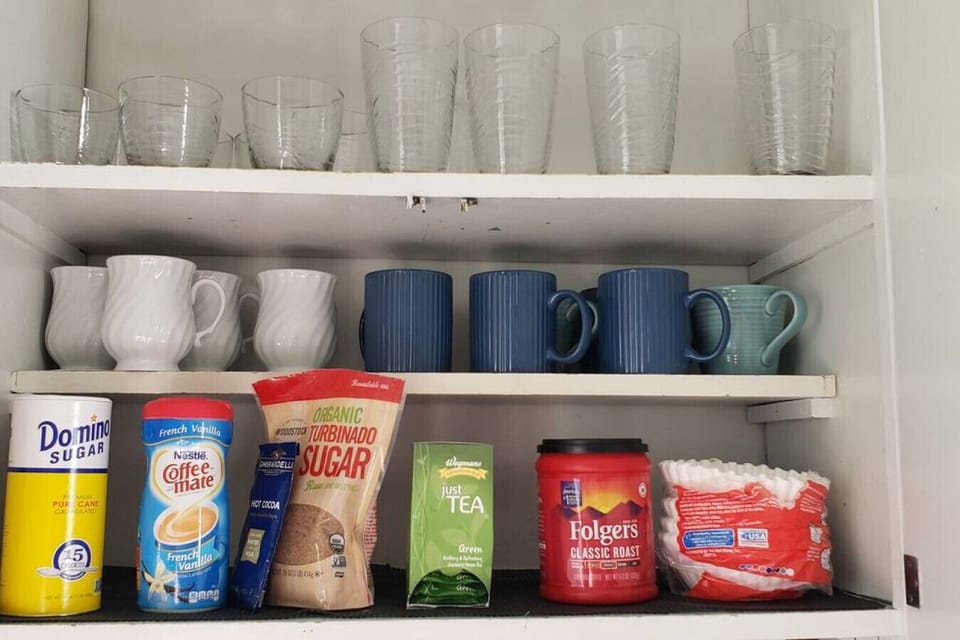 Morning coffee supplies.  Coffee, tea, sugar and creamer.   Regular 12 cup coffee pot.