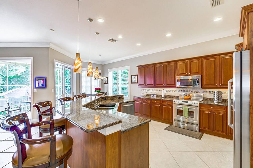 Large open stainless kitchen with granite bar and seating for 5.