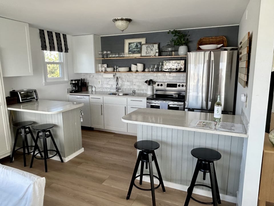 Kitchen with stainless appliances, quartz countertops and peninsula seating