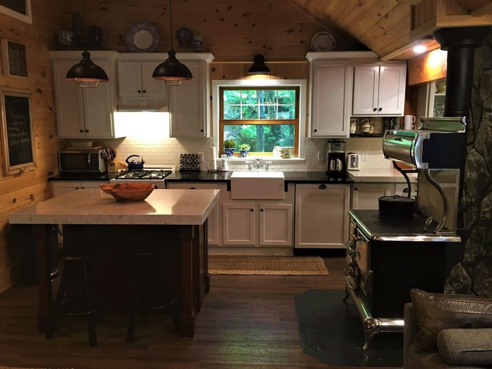 Modern cottage kitchen with farm sink, dishwasher, gas stove, microwave, etc.