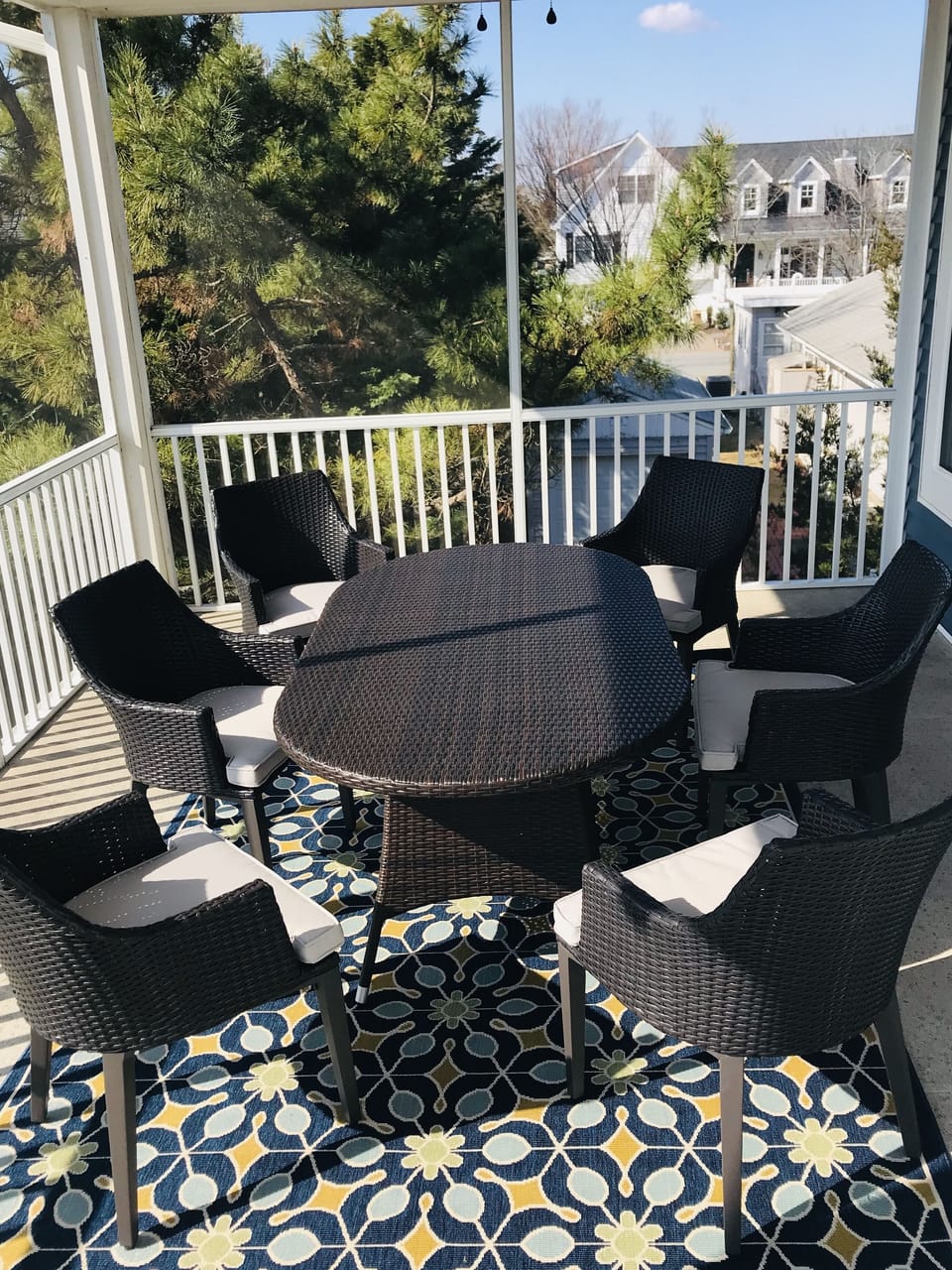 Spacious screened in porch with ceiling fan, slider opens to indoor dining area
