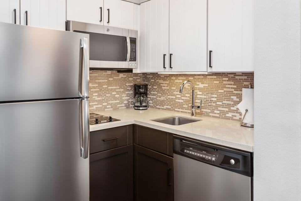 Modern kitchen equipped with stainless appliances and sleek countertops.