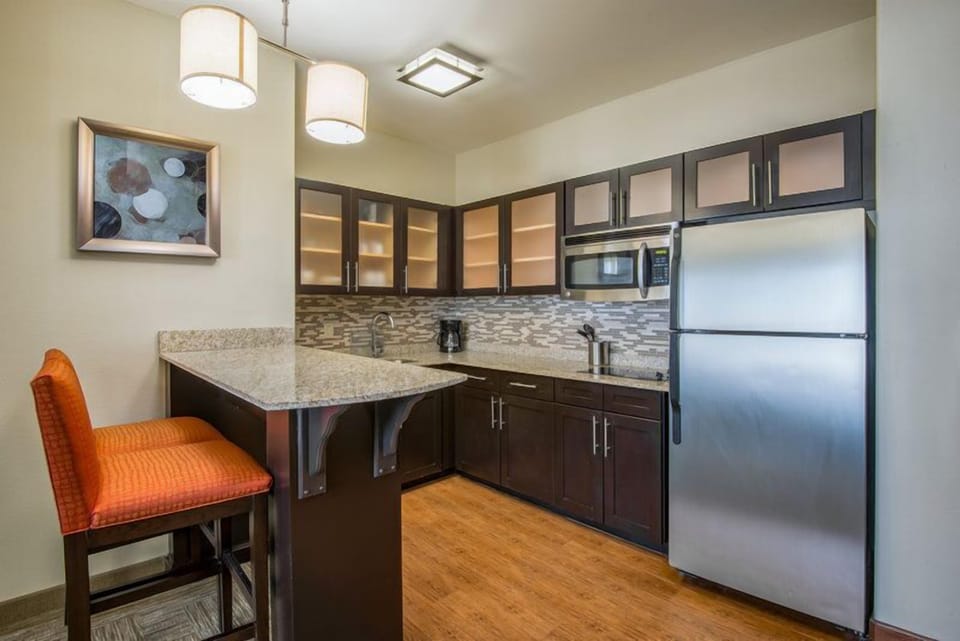 In-suite kitchen with full-size fridge, stovetop, microwave, and dishwasher