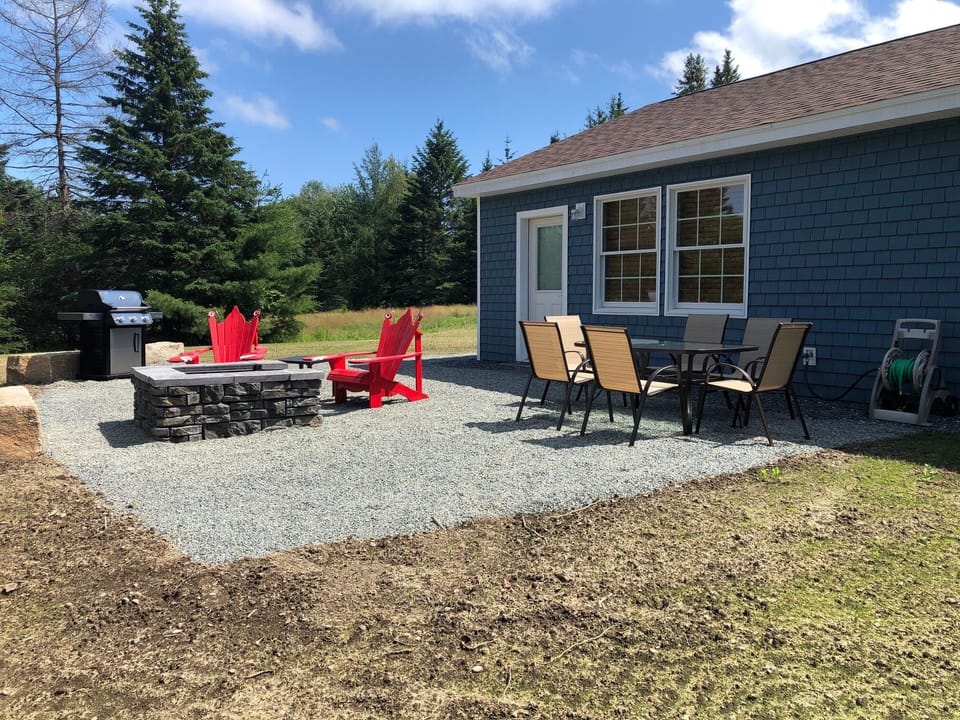 Patio off back of house with grill, fire pit and table with chairs