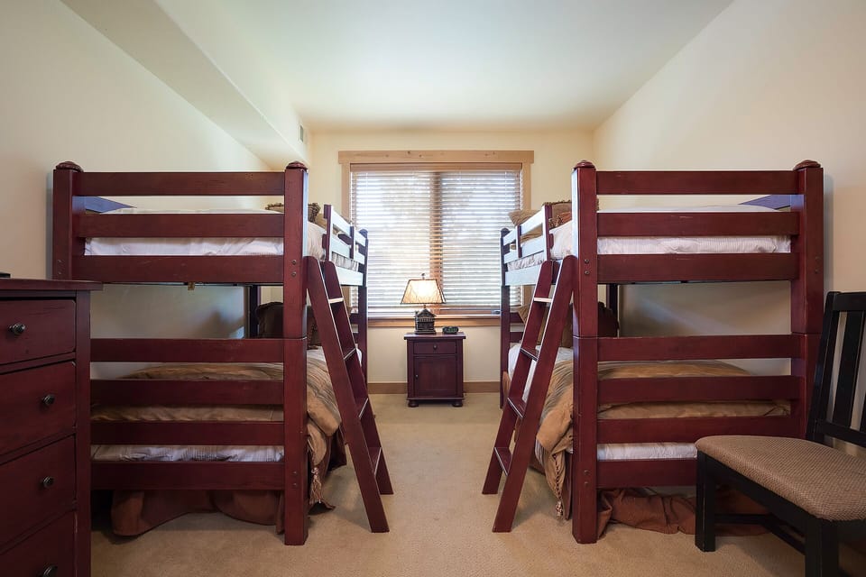Your group will love this cozy bunk room with warm wood furnishings and soft natural light streaming through the window.