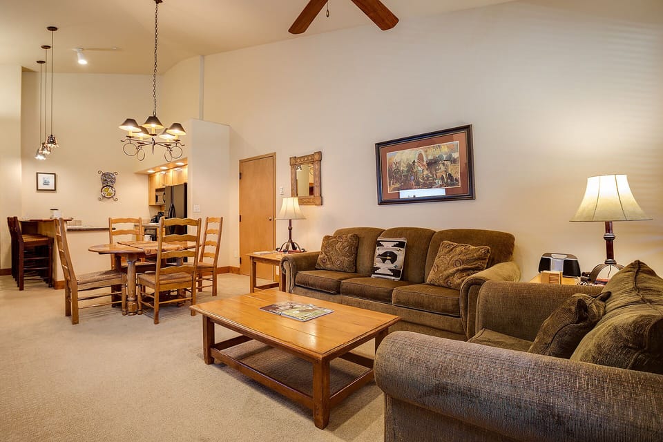 Relax in your spacious living room featuring cozy seating, warm wood accents, and an open layout connecting to your dining area.