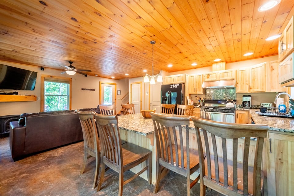 The well-equipped kitchen has a 6-burner gas stove, custom cabinets, and is fully equipped for making meals at home.