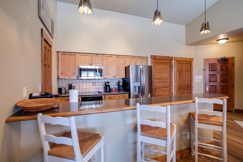 Gather around the spacious kitchen island where warm wood meets modern convenience, perfect for cooking together and sharing meals.
