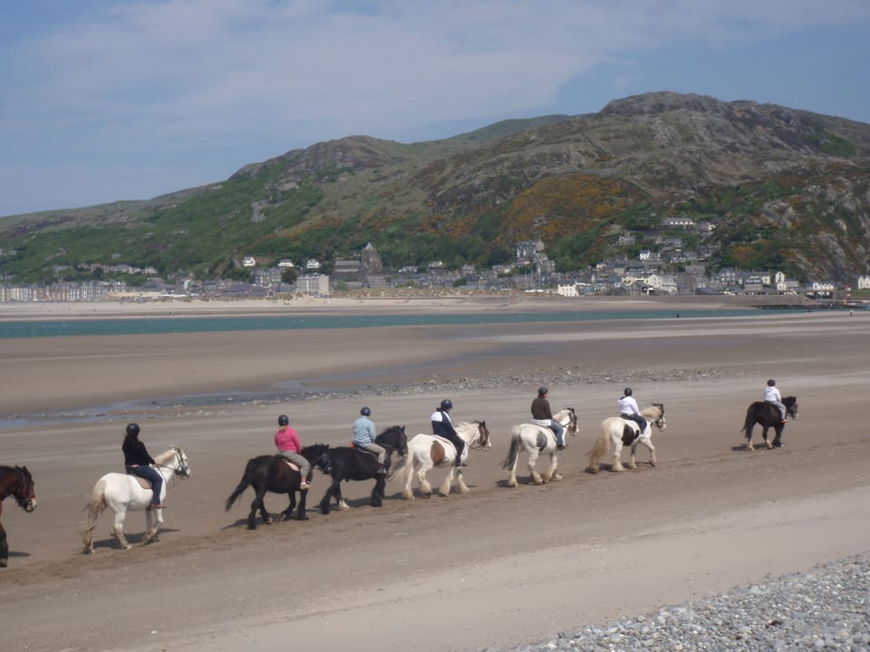Horse riding along Fairbourne Beach