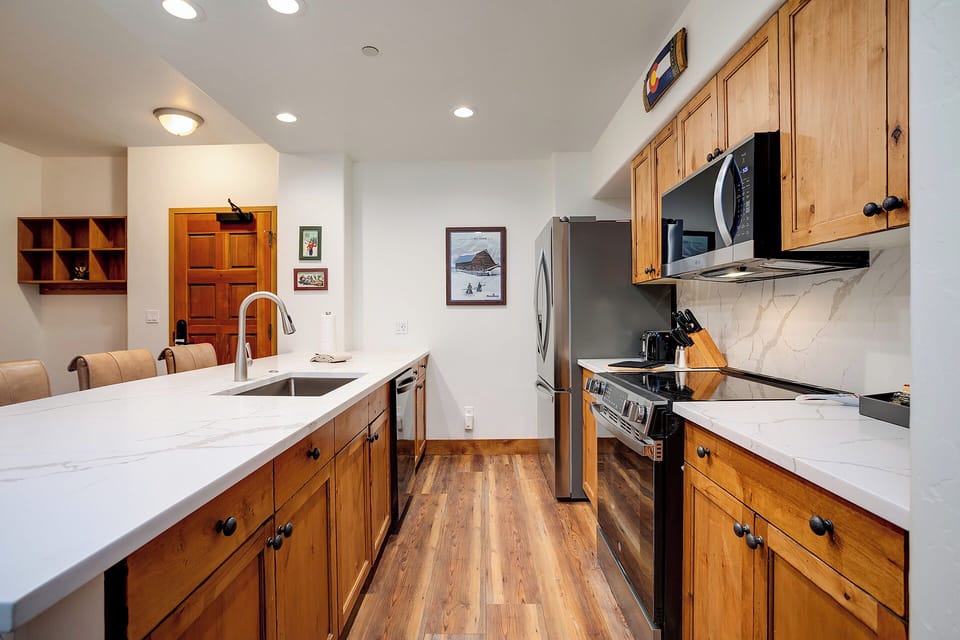Your fully equipped kitchen features elegant marble countertops, warm wood cabinets, and modern appliances—perfect for creating memorable meals during your stay.