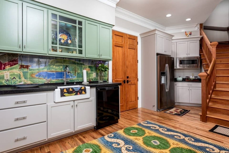 The wide and open stairwell to second story LR and bedrooms connects to kitchen
