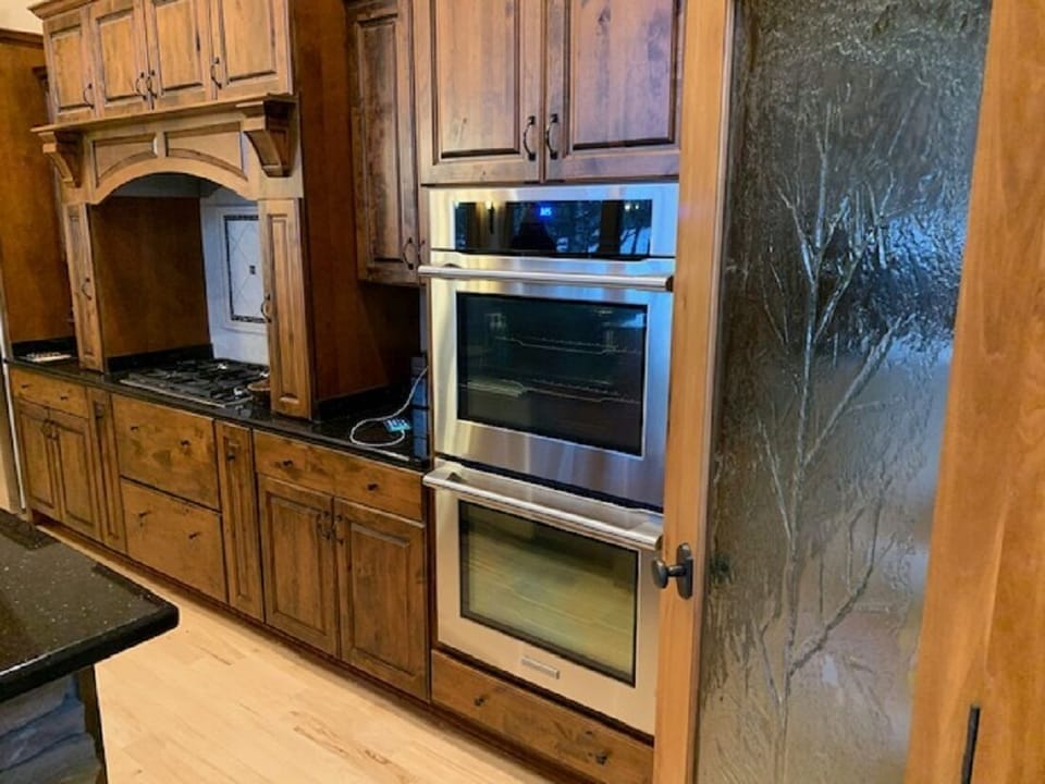 Kitchen with Electrolux double oven, dishwasher, refrigerator & wolf gas stove