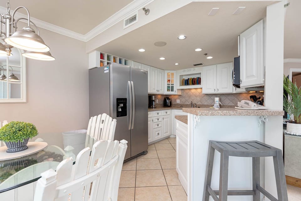 Prepare meals in the bright kitchen featuring stainless appliances, a spacious counter, and a cozy dining area