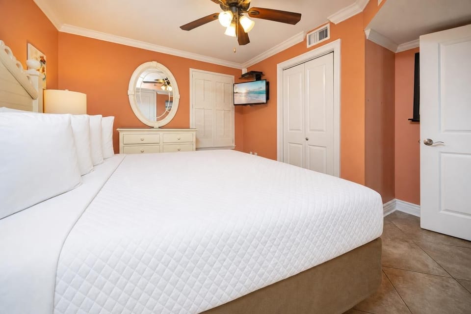 Relax in this inviting bedroom featuring a king bed, vibrant walls, and TV for your entertainment