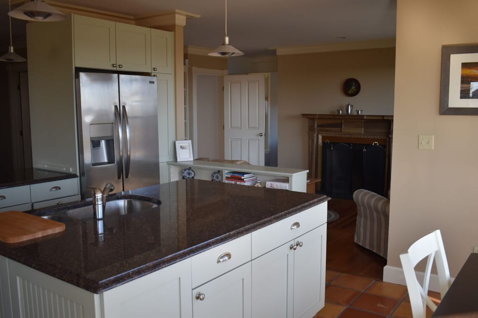 The kitchen is open to a sitting area with working fireplace 