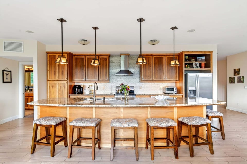 Main-level chef's kitchen with gas range, dishwasher, standard + Keurig coffee makers, and a kitchen island with seating for 6.
