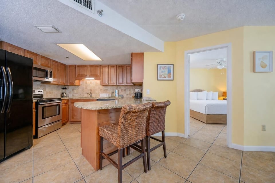 The kitchen's breakfast bar with woven stools invites casual chats as smells from cooking fill the air