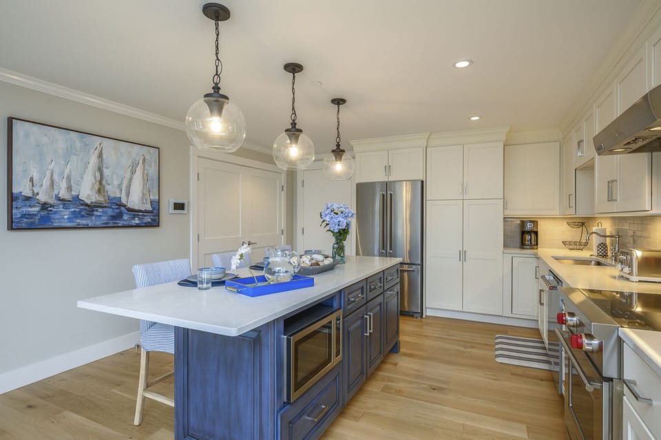 Large luxury style kitchen with center island with microwave, chefs range with oven and stainless fridge. Separate laundry behind the double doors.