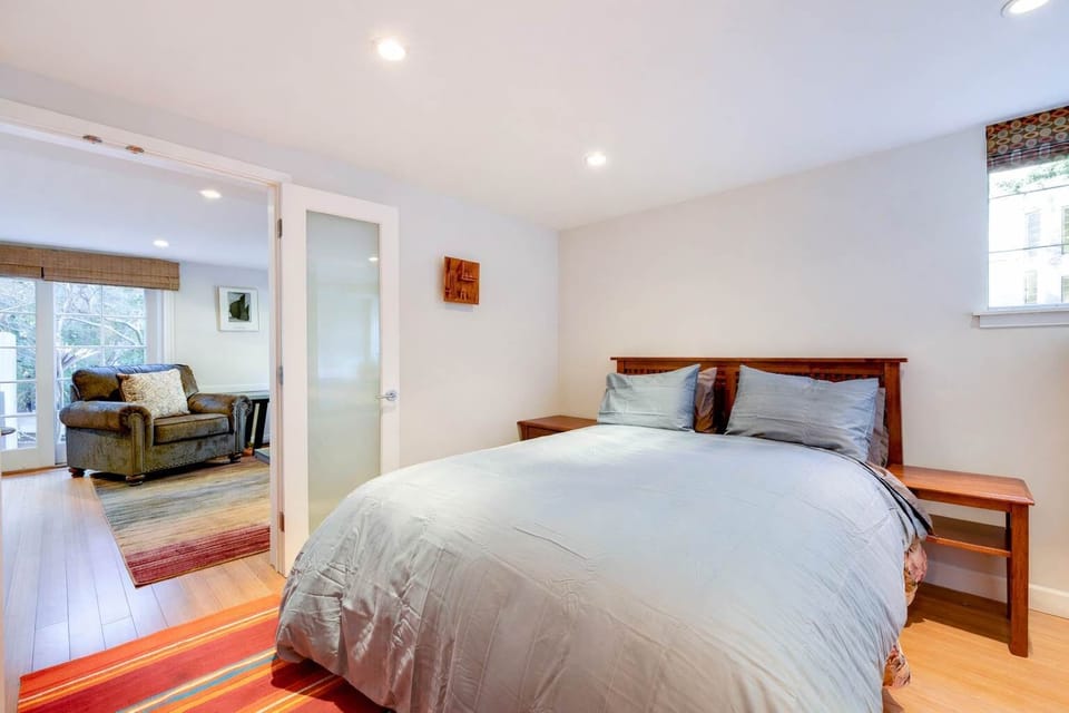 Comfortable bedroom with cozy bedding and warm lighting, offering easy access to the relaxing living area nearby.