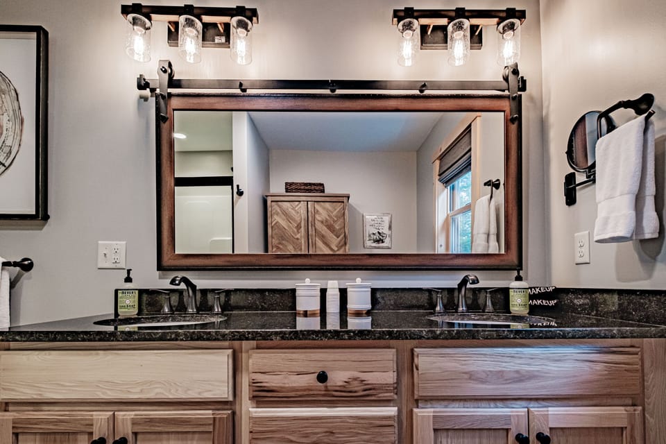 En suite bathroom has double sinks and granite countertop