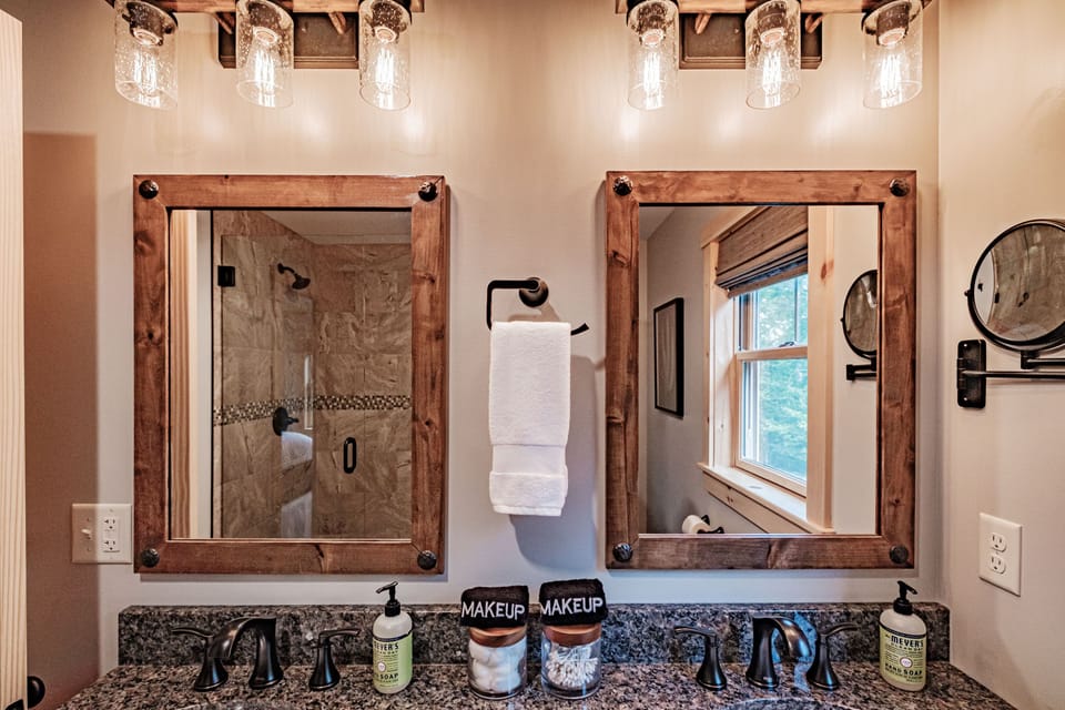 En suite bathroom has double sink vanity with granite counters