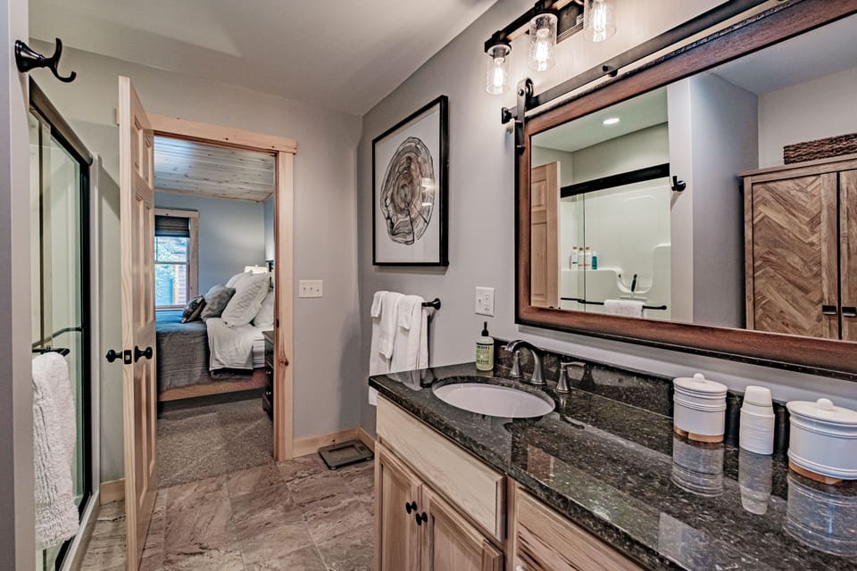 Spacious bathroom has glass door shower. Linens and and towels provided