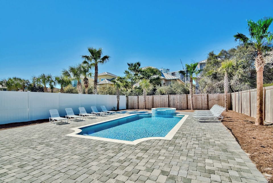 Sun-soaked courtyard pool framed by palms, perfect for cooling off after a day out.