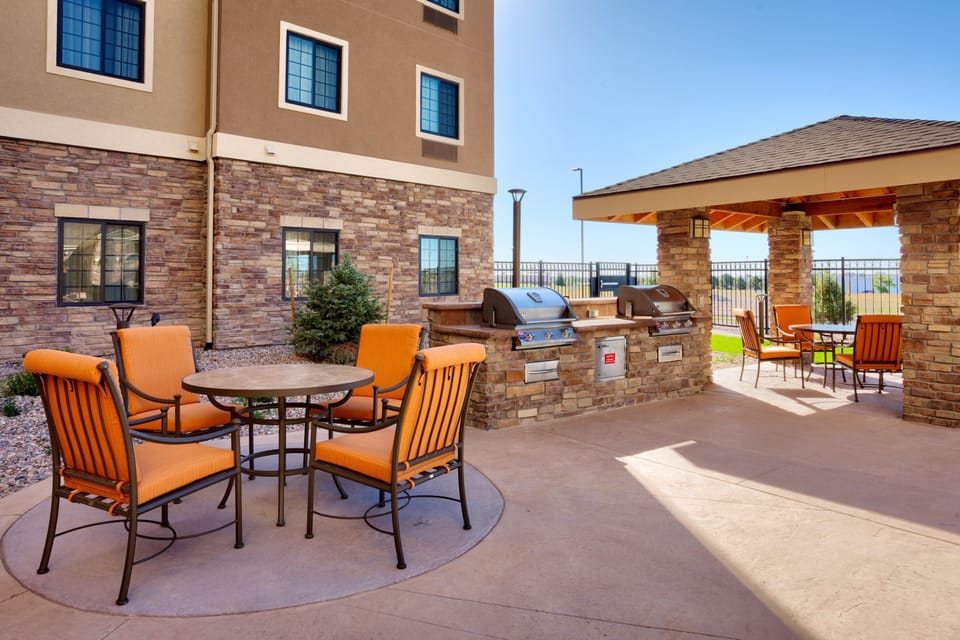 Outdoor patio with gas grills and dining tables.