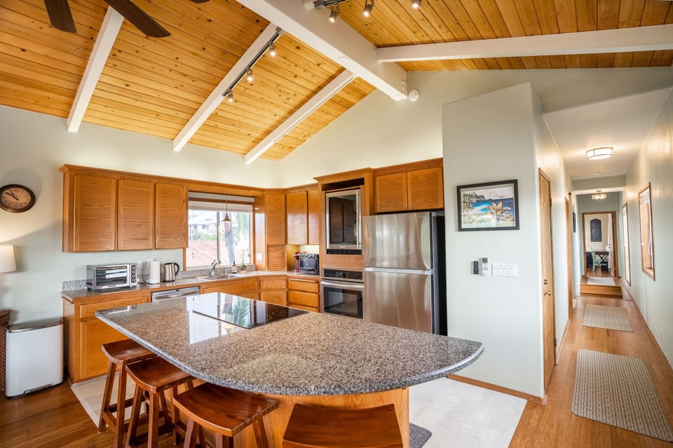 Well stocked upper kitchen has Keurig, toaster oven, stove, oven, & wine cooler