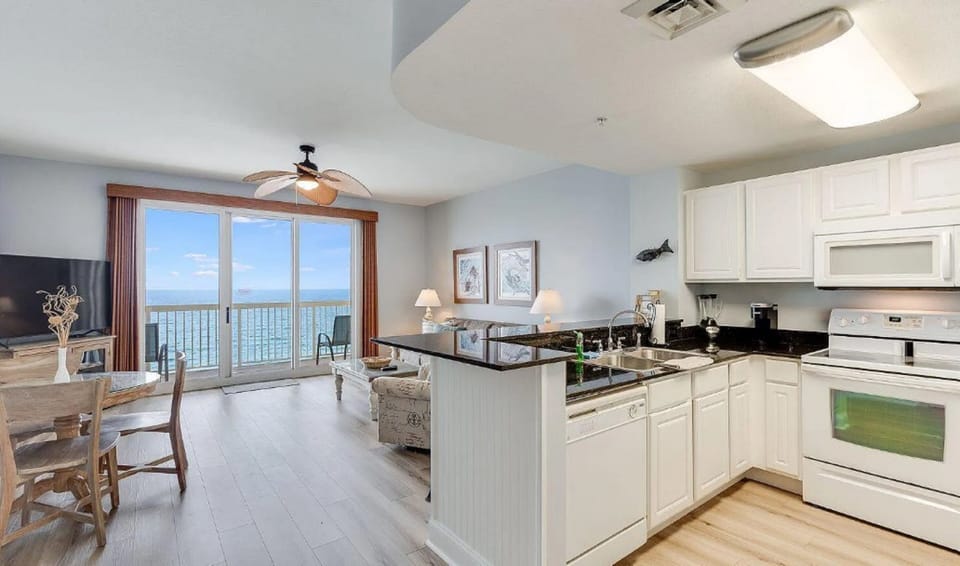 Your open-concept kitchen flows seamlessly into the living area, where stunning ocean views through floor-to-ceiling windows create the perfect backdrop for your getaway.