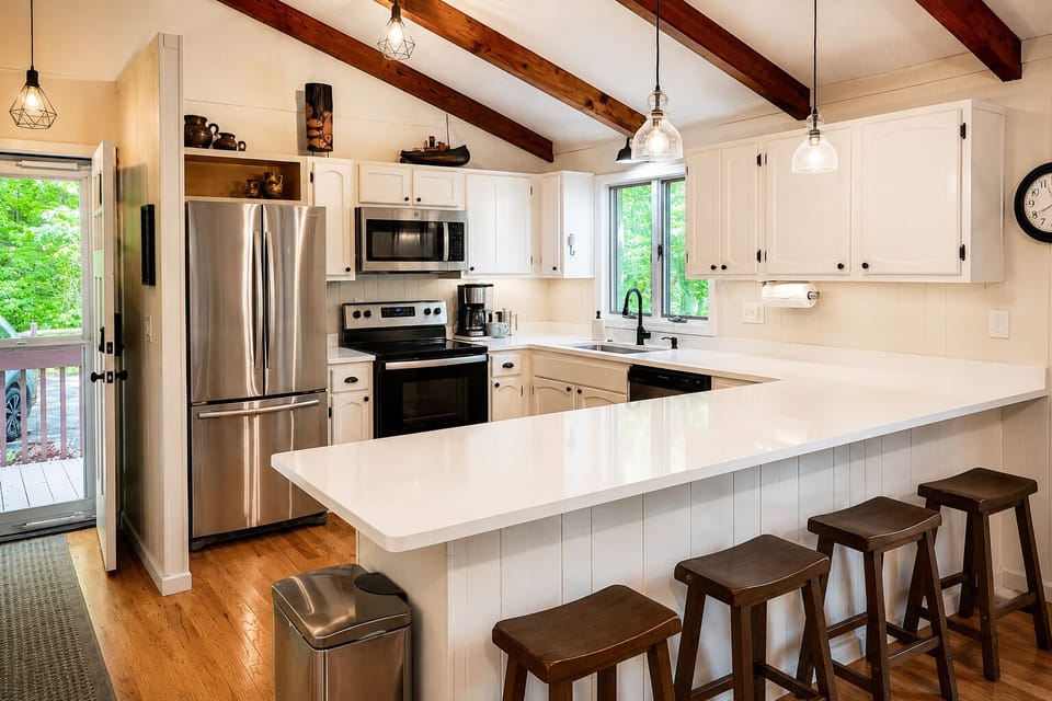 The fully equipped kitchen features quartz countertops, stainless appliances, and bar seating—perfect for everything from morning coffee to family meals.