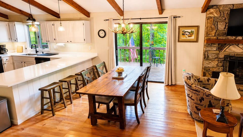 Open-concept dining area with comfortable seating, a spacious breakfast bar, and direct access to the deck. The perfect gathering space for meals, morning coffee, and planning your mountain adventures.