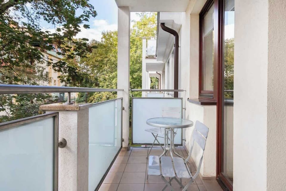 Furnished balcony with green surroundings. 
