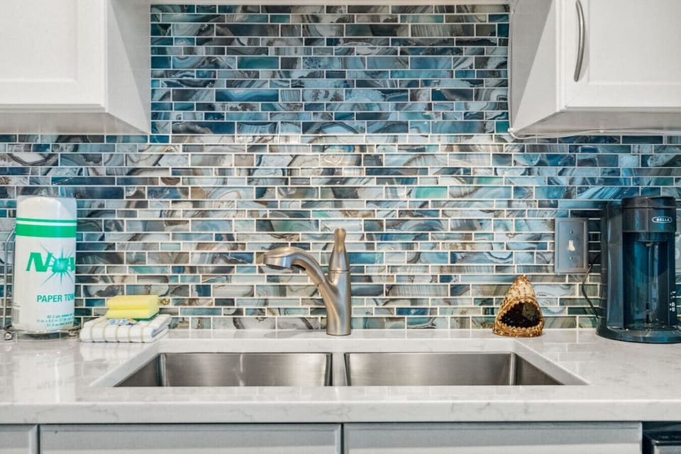 Fully stocked kitchen with island that has seating for 3 and a small dining area with seating for 2