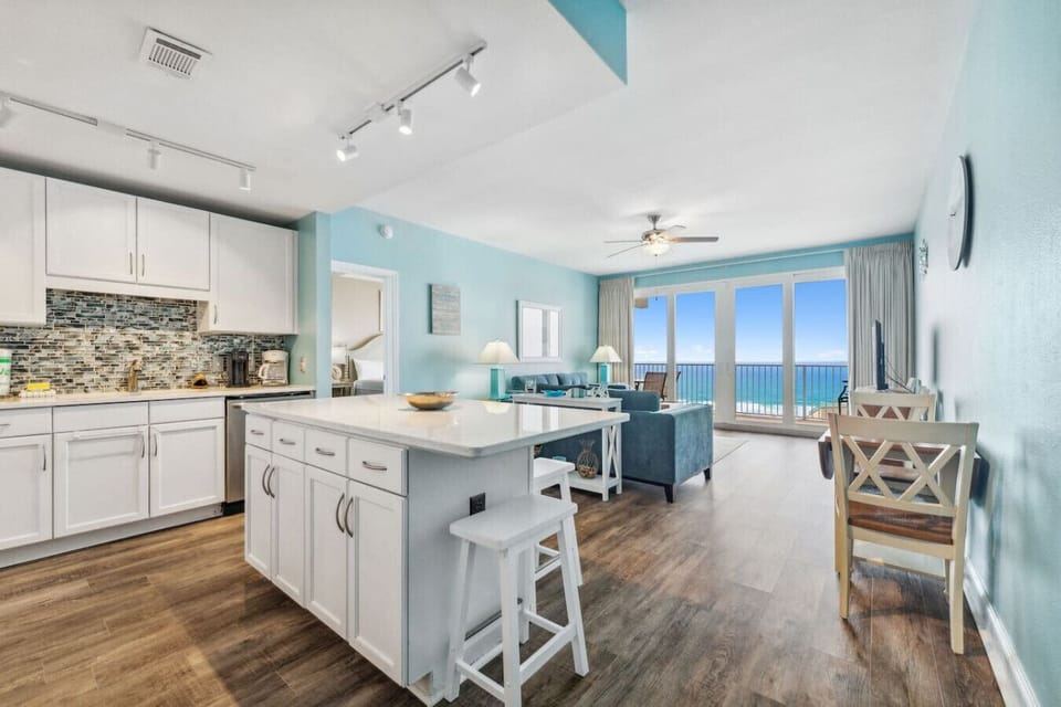 Fully stocked kitchen with island that has seating for 3 and a small dining area with seating for 3