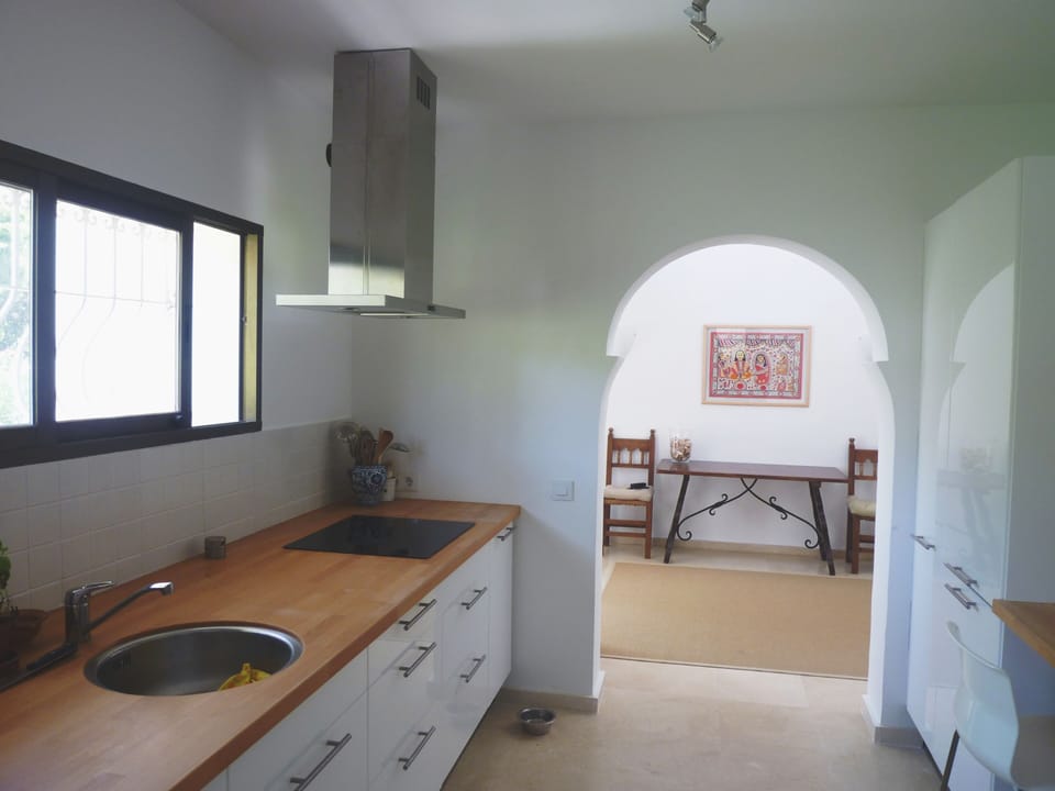 Modern kitchen, view from adjacent storeroom to entrance hall