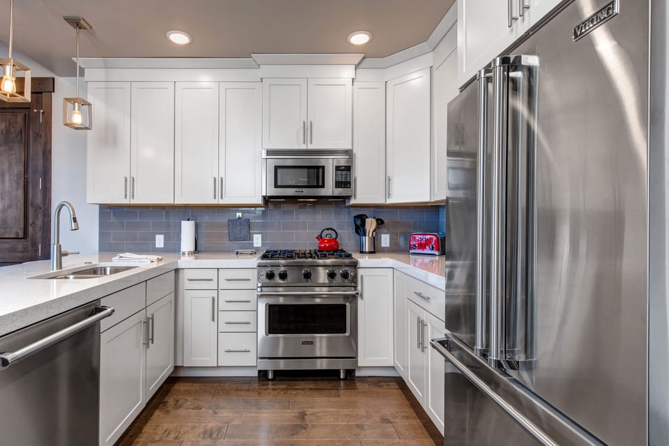 Gourmet Kitchen with Stainless Steel Viking Appliances, Stone Countertops, and Bar Seating for 3