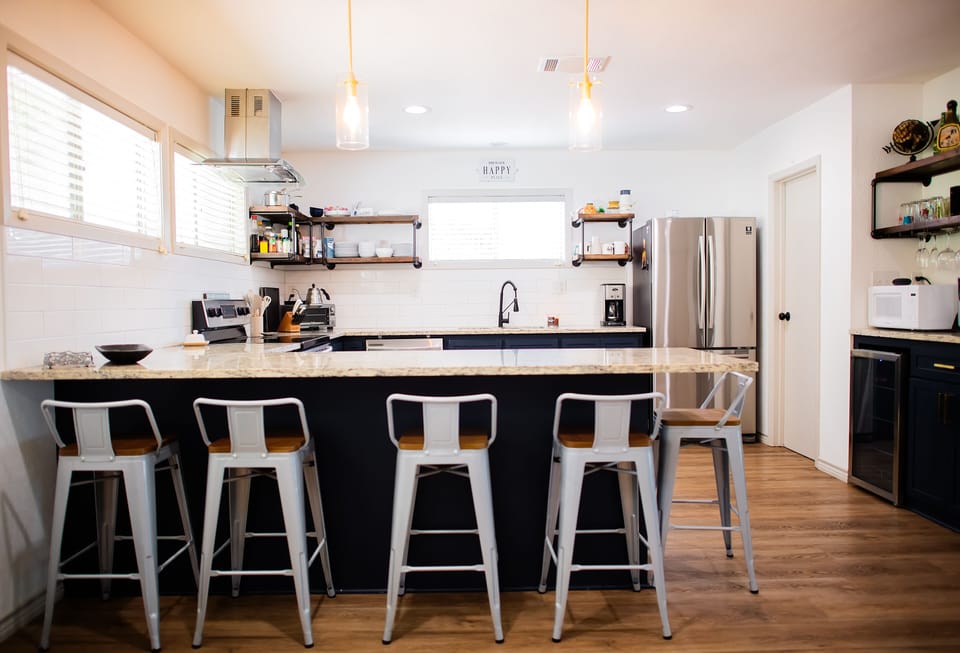 Open kitchen with stove, oven, microwave, coffee maker, toaster, and fridge