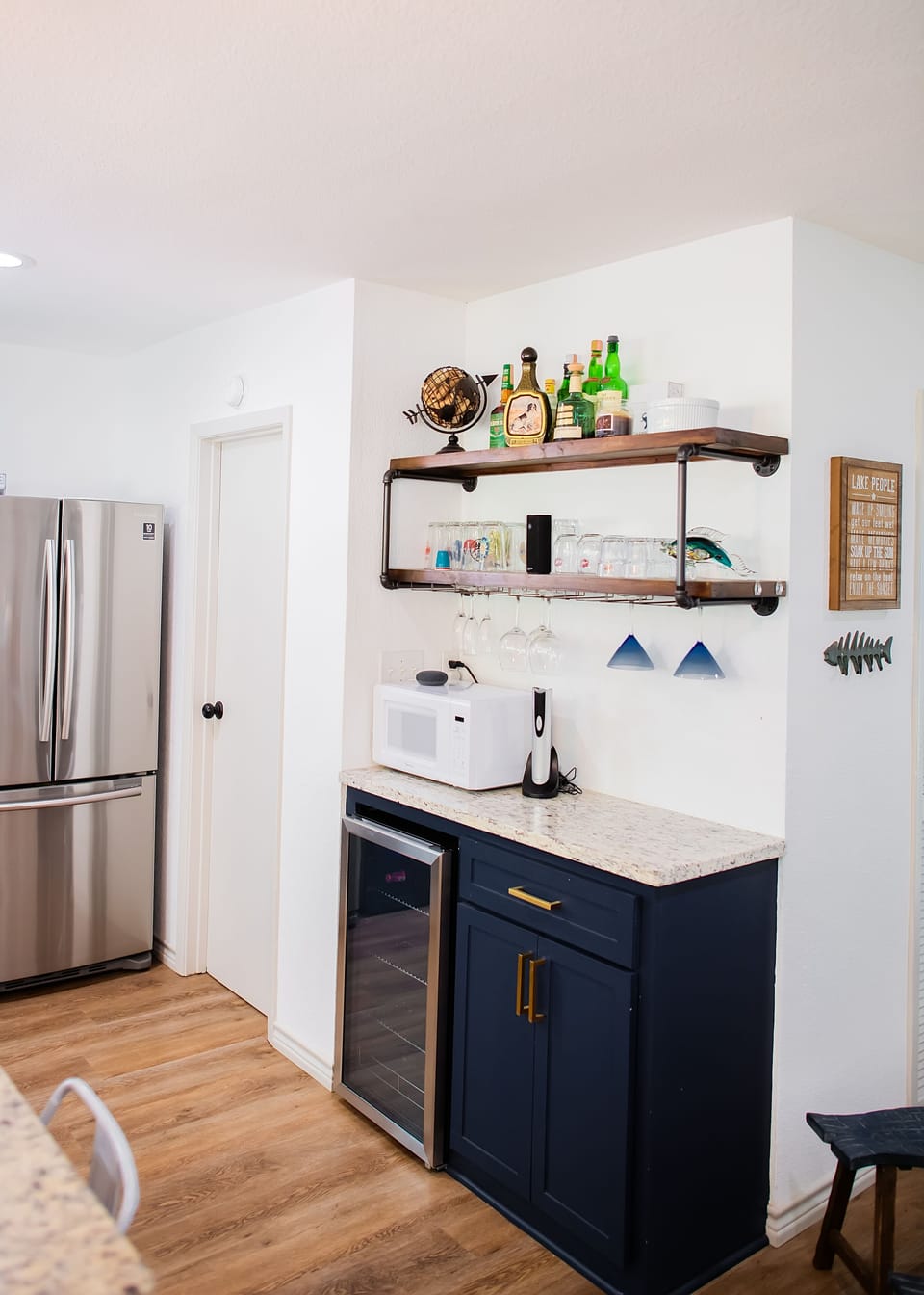 Dry bar off the kitchen with a drink fridge wine opener, and glassware
